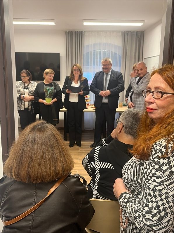 dyrektor GOPS podczas przemowy - obok wójt gminy, przedstawiciele rady i seniorów; z przodu goście